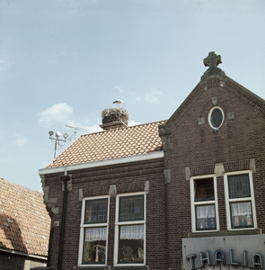 119958 Afbeelding van een ooievaar op zijn nest op het dak van het hoekhuis Oude Huijgensteeg en Kapellestraat te Oudewater.